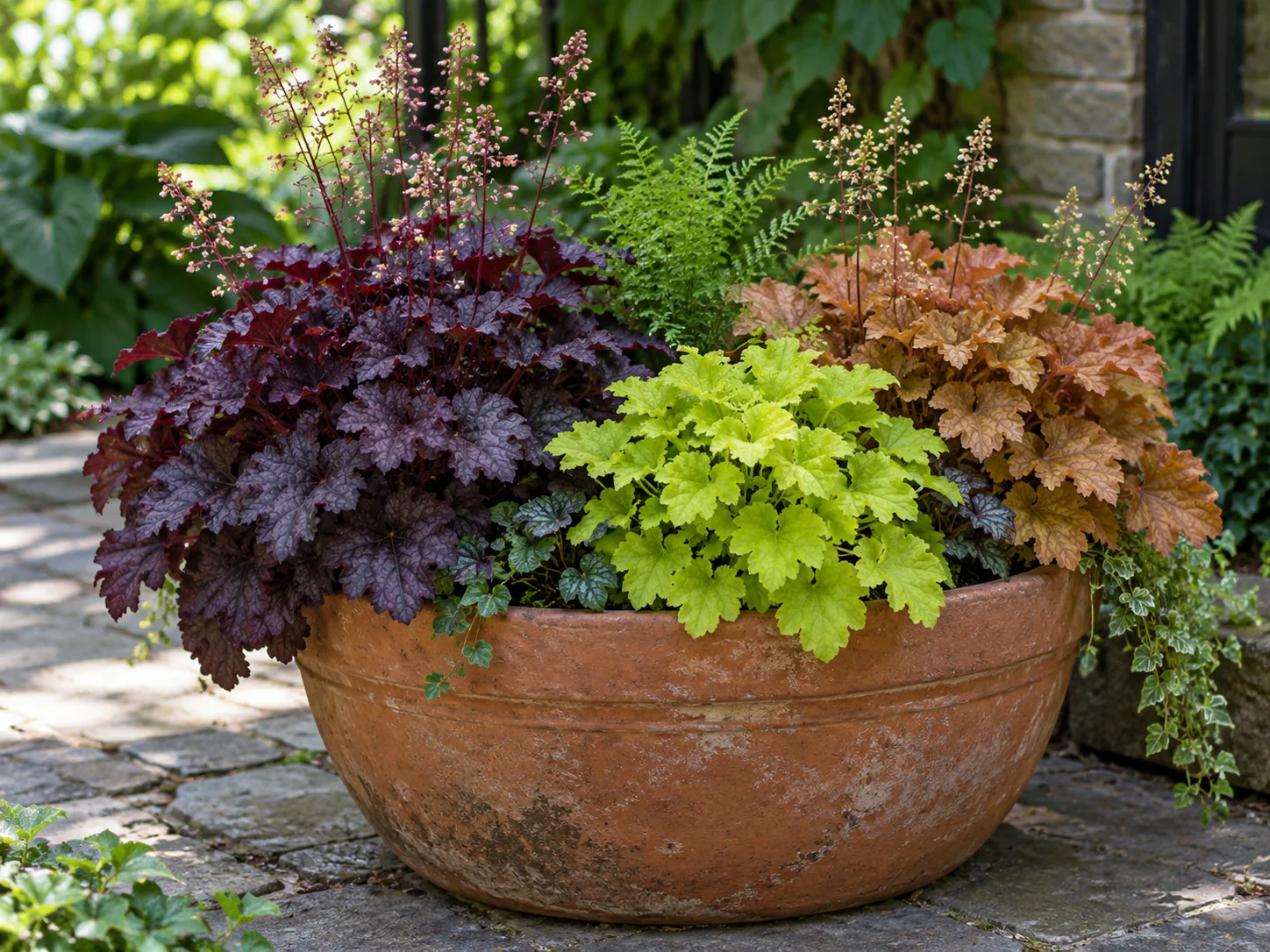 Burgundy, chartreuse, and caramel coral bells arranged in a shaded patio container